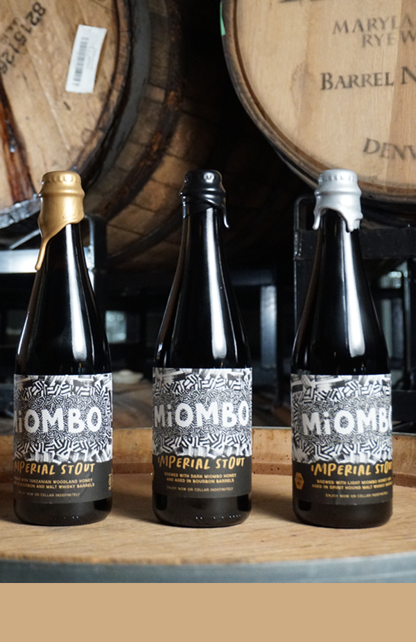 Three bottles of Miombo Imperial Stout on barrel